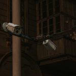 Câmeras de segurança instaladas em um poste, voltadas para uma via urbana.