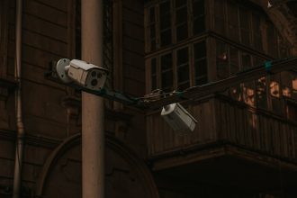 Câmeras de segurança instaladas em um poste, voltadas para uma via urbana.