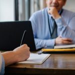 Pessoa preenche um formulário enquanto se candidata a uma vaga de emprego em um escritório.